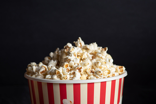 Sweet popcorn box with popcorn on black background