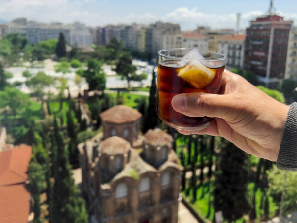 istock Hand holding a cold brew coffee against city background. 1399366165