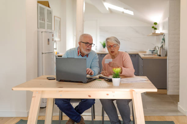 istock Senior Woman Holding Credit Card and Using Laptop Computer While Paying Bills at Home With Credit Card. 1399367700
