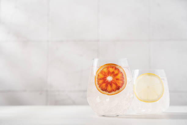 istock Cold water with red orange and lemon in glasses on white background 1399370538