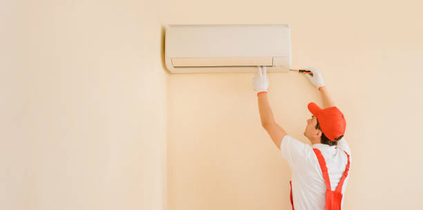 istock Man professional technician in red overall fixing the AC air conditioner 1399370628