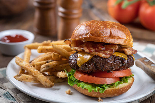 cheeseburger z boczkiem na prażonej bułce - sandwich plate food french fries zdjęcia i obrazy z banku zdjęć