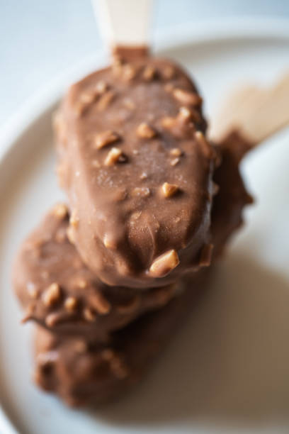 istock Three almond vanilla ice cream on a stick with chocolate glaze. 1399371852