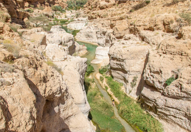 The wonderful Wadi Shab, Oman Tiwi, Oman - famous of its vertical cliffs and the green water, Wadi Shab is one of the most beautiful wadi in Oman, and a very popular tourist destination wadi shab stock pictures, royalty-free photos & images