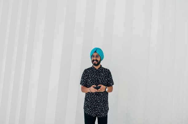 istock Portrait Of A Happy Man Using Mobile Phone While Standing In Front Of White Geometric Wall 1399375093