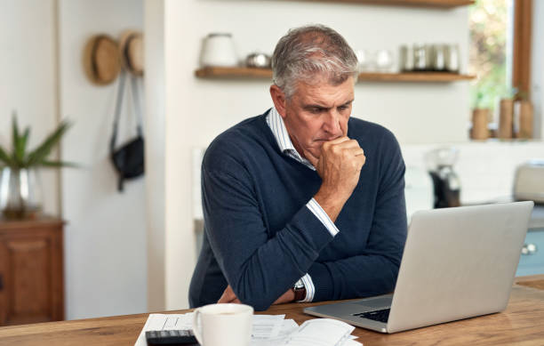 istock A senior man planning his finance and paying bills while using laptop at home. A mature man going through paperwork and working online with a computer 1399375122