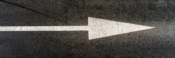 istock white marking of arrow form located on grey asphalt road 1399379850