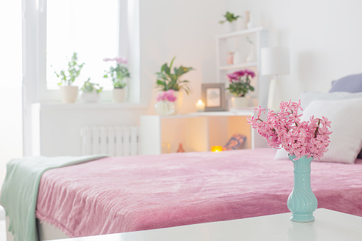 pink and white interior of bedroom with spring flowers