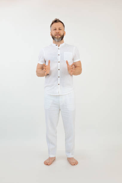 istock Vertical studio shot handsome barefoot man explaining something in white outfit. Healthy sports lifestyle. Copy space 1399381406