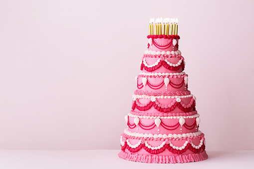 Extravagante pastel de cumpleaños rosa escalonado decorado con tuberías de crema de mantequilla vintage photo