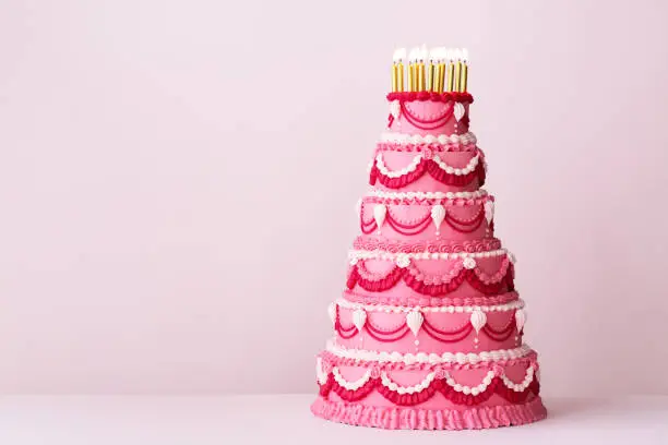 Photo of Extravagant pink tiered birthday cake decorated with vintage buttercream piping