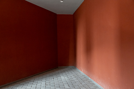 A corner of a building illuminated by red walls and gray bricks