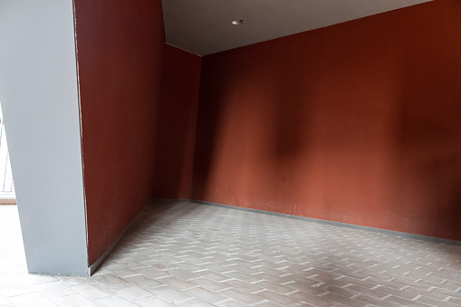 A corner of a building illuminated by red walls and gray bricks