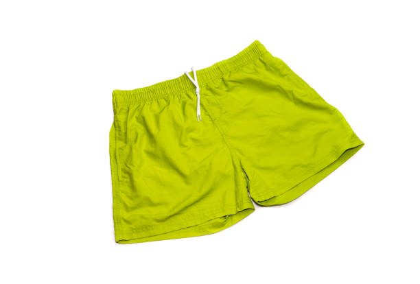 grüne, männliche badehose auf weißem grund - beach shorts stock-fotos und bilder