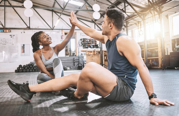 istock Trainer giving his client a high five after a workout. Young friends working out together. Friends motivate each other in the gym. Sporty, excited friends exercise together in the gym 1399390894