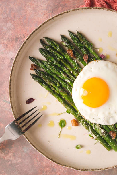 istock grilled asparagus, with fried egg, spices and herbs, parmesan cheese, on a beige plate, top view, rustic, no people 1399390977