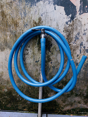 the blue hose that surrounds the water faucet in front of the house