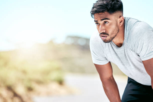 istock Fit young mixed race man resting while exercising outdoors. Handsome hispanic male athlete taking a break and looking exhausted while working out outside. Cardio and endurance training for fitness 1399392534