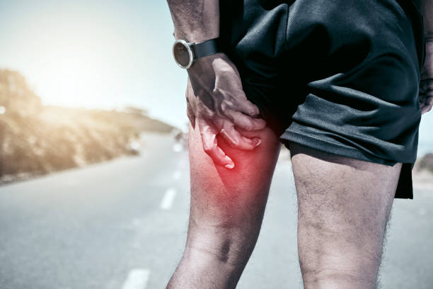 istock Closeup fit mixed race man holding his leg in pain while exercising outdoors. Unrecognizable male athlete suffering with a muscle hamstring injury highlighted by cgi. You can get hurt during a workout 1399392562