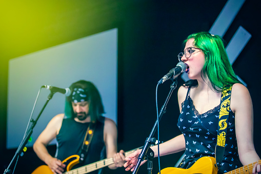 A female fronted pop punk band performing a live concert.