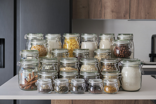 Variety of dry foods, grains, nuts, cereals in glass jars. Zero waste storage concept.