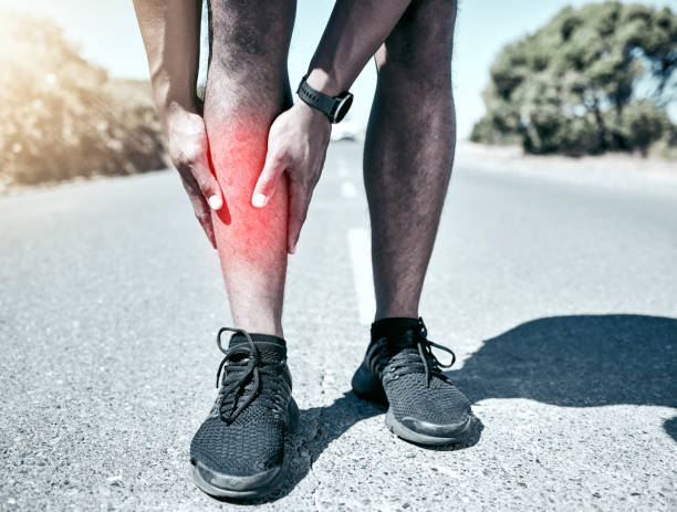 Closeup fit mixed race man holding his leg in pain while exercising outdoors. Unrecognizable male athlete suffering with shin splints highlighted by glowing cgi. You can get hurt during a workout Closeup fit mixed race man holding his leg in pain while exercising outdoors. Unrecognizable male athlete suffering with shin splints highlighted by glowing cgi. You can get hurt during a workout shin stock pictures, royalty-free photos & images