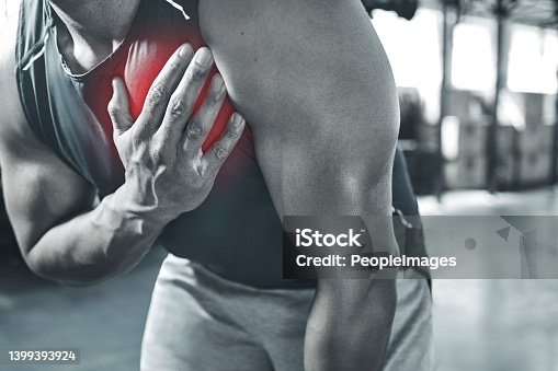 istock Is this a heart attack? Trainer experiencing chest pains at the gym. Hand of a bodybuilder touching his chest in pain. Red CGI spots are used to show pain. Your heart may be in danger with exercise 1399393924