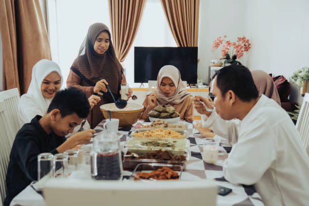 gruppo di amici riuniti intorno al tavolo con cibo e bevande, divertersi insieme - islam child indian culture ethnic foto e immagini stock
