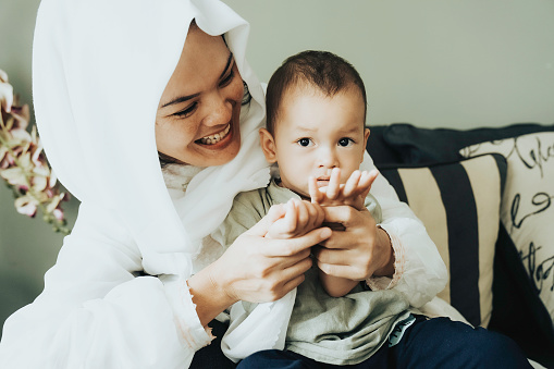 Asian muslim mother teach her child praying