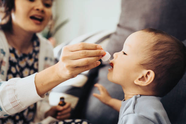 bebê recebendo medicina oral - baby toddler child flower - fotografias e filmes do acervo