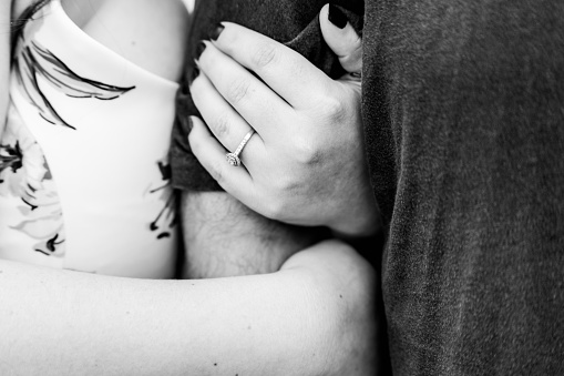 Foto en blanco y negro de mujeres sosteniendo el brazo de los hombres con un anillo de compromiso photo