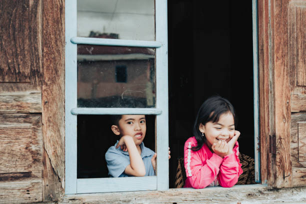 dzieci robiące śmieszne miny w oknie - child asian and indian ethnicities facial expression asia zdjęcia i obrazy z banku zdjęć