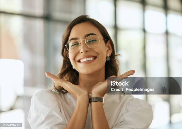 Cheerful Business Woman With Glasses Posing With Her Hands Under Her Face Showing Her Smile In An Office Playful Hispanic Female Entrepreneur Looking Happy And Excited At Workplace Stock Photo - Download Image Now