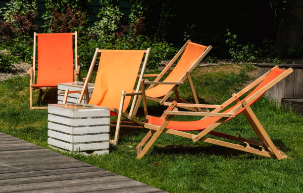 pomarańczowe leżaki w zielonym ogrodzie letnim - deck chair summer grass outdoor chair zdjęcia i obrazy z banku zdjęć