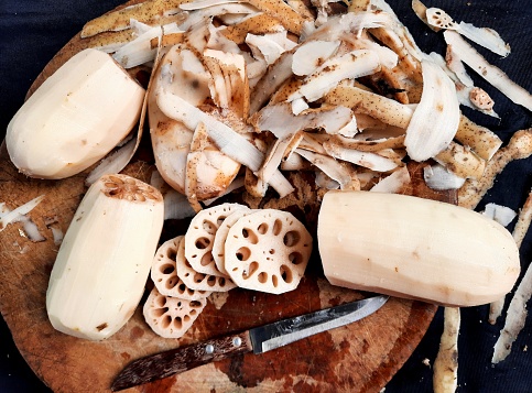 Peeling and cutting Lotus Roots on cutting board - food preparation.