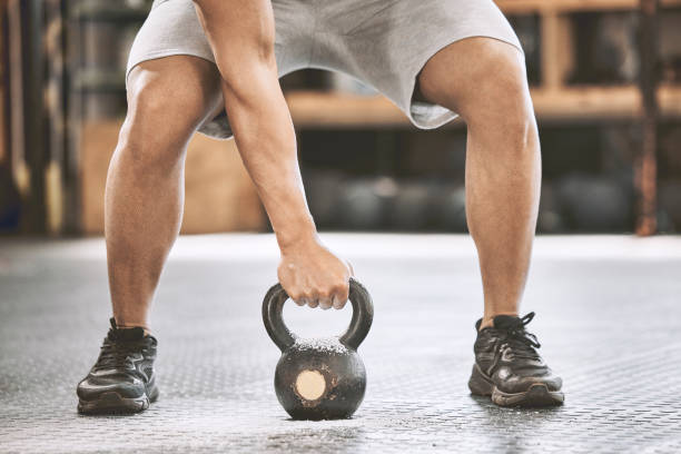 istock Fit athlete lifting a heavy kettlebell. Strong bodybuilder doing an arm exercise. Bodybuilder lifting weights in the gym cropped. Bodybuilding endurance strength training builds strong muscle 1399396940