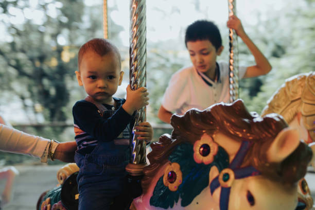 Portrait of a cute elementary age Eurasian girl of Filipino descent smiling directly at the camera while riding on a carousel.