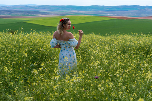 Happy Young Woman at Fields in Springtime