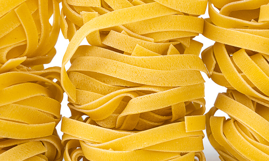 Macro of raw pasta. Food pasta background. fettuccine, nests.