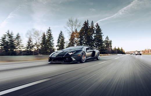 Seattle, WA, USA\n2/2/2022\nBlack Lamborghini Huracan driving on the highway