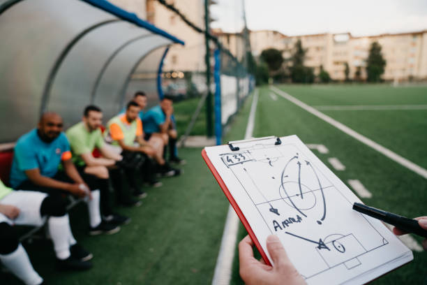 el entrenador está explicando las tácticas al equipo de fútbol - football strategy plan sport fotografías e imágenes de stock