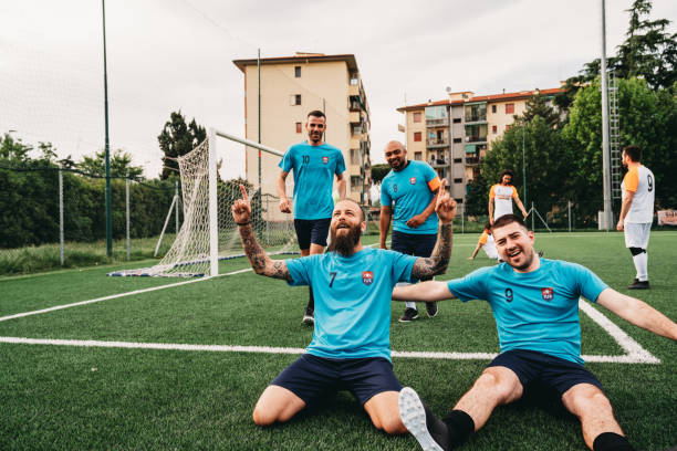 jogadores de um time de futebol estão comemorando juntos após um gol - sports uniform blue team event sports activity - fotografias e filmes do acervo