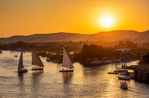 Beautiful view on felucca boats on Nile river in Aswan at sunset, Egypt