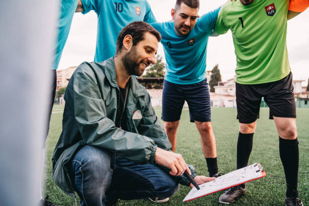 el entrenador está explicando sus tácticas al equipo de fútbol - football strategy plan sport fotografías e imágenes de stock