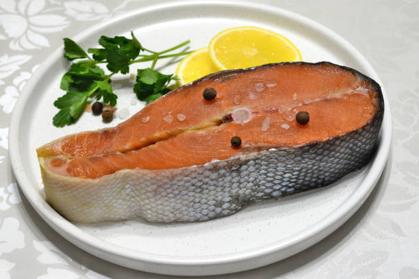 istock raw salmon on white plate with lemon and parsley, close-up 1399402589