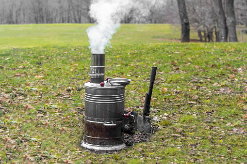 Samovar smoking and burning on the grass in nature. for tea and coffee at camping and picnic