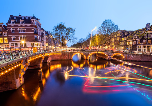 Amazing Light trails and reflections on water at the Brouwersgracht and Keizersgracht canals in Amsterdam at evening. Long exposure shot. romantic city trip concept.