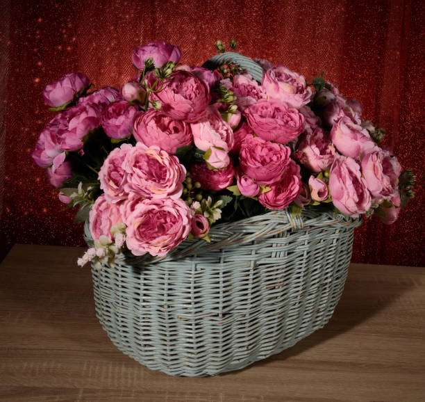 Flowers in basket on wooden background stock photo