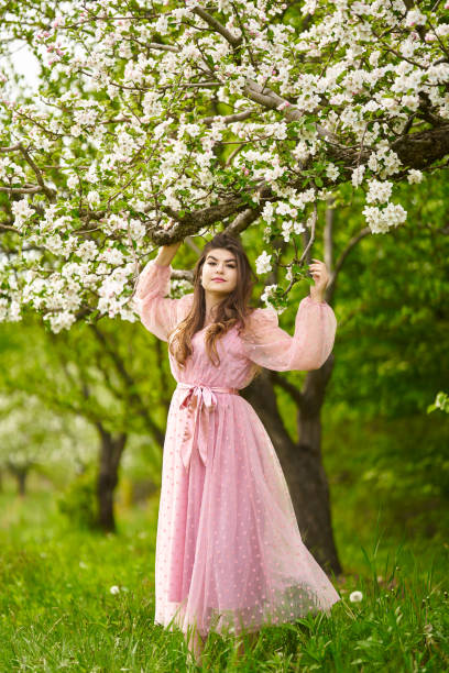 istock Young woman in apple orchard 1399410307