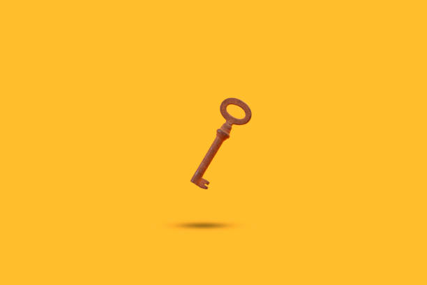 istock Rusted old metal key floating on a yellow background with shadow 1399410578